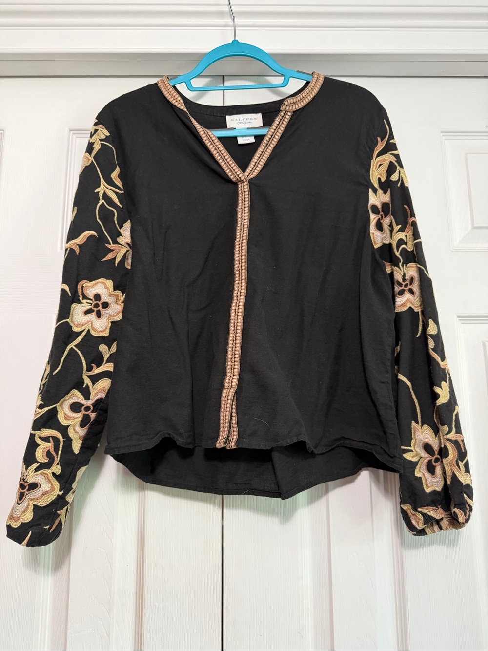 This black Calypso St. Barth long-sleeve blouse features striking beige and gold